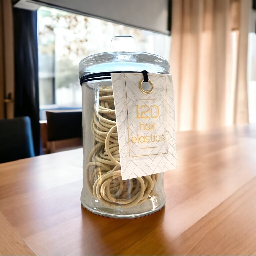 A glass jar of hair elastics new